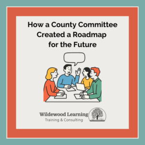Four people sit at a table, talking and taking notes, under the text: How a County Committee Created a Roadmap for the Future. Wildewood Learning logo and name appear below.